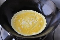 鍋里抹少許油，鍋熱后倒入適量雞蛋液，輕輕轉動鍋，使雞蛋液攤勻。