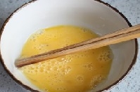 雞蛋液打入碗中，蛋液中加少許精鹽，用力攪拌蛋液，蛋黃和蛋清打散均勻。