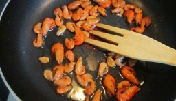 在鍋內倒油用大火把蝦子炒至變紅出鍋；