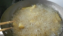 鍋中倒油燒熱把土豆放進去炸至金黃撈出；