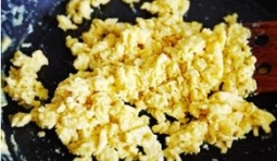 炒鍋里放油加熱，把拌勻的蛋液炒熟成蛋花裝盤；