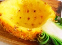 挑選一個稍大的菠蘿，對開切，用小刀挖取菠蘿肉；做成菠蘿盅；