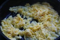 熱油鍋，加入比平時炒菜還要多的油，油溫要高，倒入蛋液迅速攪拌成小塊；