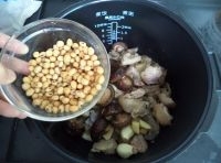 往鍋內加入姜和蒜，再加入泡軟的冬菇和洗凈的黃豆；