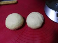 然後麵糰發酵兩倍大。再將麵糰分為兩份滾圓靜置；