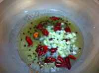 鍋內油燒熱放入干辣椒、花椒、蒜末煸香；