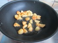 鍋中油燒至七成熱，入土豆塊，小火煎制起黃殼關火；