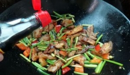  野韭菜苔、紅椒放進去翻炒至斷生后加料酒、醬油、雞精炒勻；