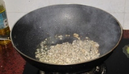 鍋燒熱后把姜、蒜放進去爆香，再把蜆肉放進去翻炒；