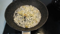 在鍋里加入適量的油燒熱，倒入切好生薑和大蒜輕輕攪拌；