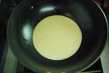 用刷子在平底鍋里刷入一層薄油，開小火，把攪拌均蛋麵糊鋪平在鍋底；
