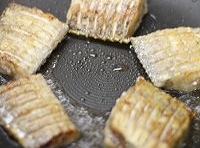 炒鍋中加入適量的油燒熱后，放入切塊的帶魚煎制兩面泛金黃色；
