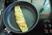 等到鍋中蛋餅的表面開始凝固時，從一邊捲起，再繼續煎熟即可。

