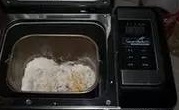 放涼的南瓜泥，放入麵包機桶中，加入麵粉、糖、酵母粉和適量水，並攪拌成麵糊狀；