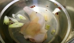 雞腿冷水下鍋、把薑片、大蔥結、花椒粒放進去煮熟；
