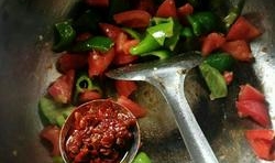 炒出辣味后，加入西紅柿塊翻炒一會兒，再倒入適量的豆瓣醬炒出紅油；