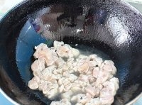 燒熱炒鍋，加入適量的油，待油熱后，下入腌至好的雞肉炒至，直到變色后再撈出；