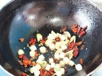 鍋中留有少許的底油，放入薑片和蒜片炒香,加入干紅辣椒段炒至，直到變成棕紅色，再下入花椒粒;
