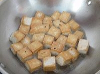 炒鍋中加入適量的油，燒熱后，下入豆腐塊，煎至兩面金黃后，撈出；
