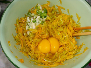 南瓜絲中放入兩個雞蛋、蔥花、鹽、胡椒粉攪拌均勻。