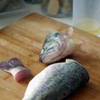 鱸魚去腮去鱗清洗乾淨，切記不能開膛，用刀分成頭，身，尾，三段，切好後再從魚身前段將內臟挖出，清洗乾淨
