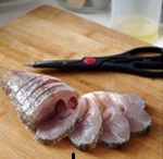 刀和剪一起上，把魚身從魚背部往魚肚方向切片，不可切斷，也就是說魚肚部分是相連的。每片厚度0.8-1cm