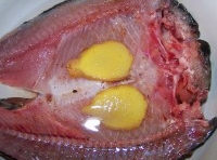 將魚置於碗中，在魚的身上抹上鹽，撒上孜然粉和廣東米酒；