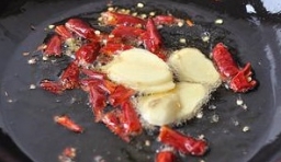 炒鍋內倒點油加熱后把干辣椒、蒜瓣、花椒用中小火炸香；