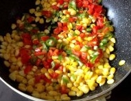 熱油鍋，大火燒至7成熱時，倒入玉米粒和青紅椒末，翻炒一分鐘；