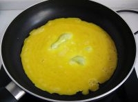 平底鍋里倒油，要鋪滿鍋底把蛋液倒進去烘成蛋餅；