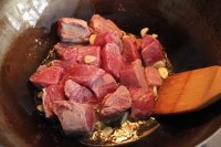 鍋里倒點橄欖油，放入蒜粒冒泡后把牛肉倒進去翻炒至變色；