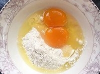 取適量麵粉在碗里，打散雞蛋后加點鹽、清水拌勻成麵糊；