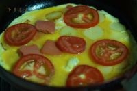 把西紅柿片也放進去，蓋上蓋子，使蛋液凝固；
