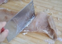 煮好的豬皮撈出后晾涼用刀刮掉油脂；