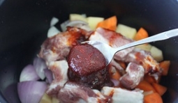 排骨洗凈后切成段，和土豆、胡蘿蔔、洋蔥放入內膽中，加入辣醬等所有調料；