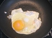 鍋里油熱后，把雞蛋液倒進去煎成荷包蛋，煎老點；