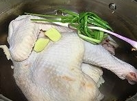 雞肉處理乾淨，在湯鍋里加滿清水，放薑片、蔥結和花椒進去；