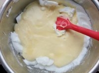用攪拌刀把三分之一的蛋清糊拌入蛋黃糊中。再把混合好的麵糊全部倒入蛋清糊中，切拌均勻；