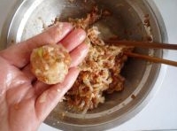 取一團蘿蔔豬肉餡團成丸子，在生粉里均勻的滾一圈；