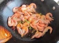  放進蔥、姜、蒜瓣炒香，把大蝦放進去翻炒；