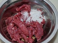 牛肉片放入碗里，加澱粉、料酒、鹽進去抓勻腌制十分鐘；