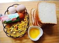 雞蛋打散成蛋液，火腿切成片，玉米粒在開水鍋里焯水；