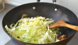 切好的圓白菜控干水后倒進去翻炒至變軟；