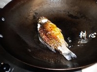 將鯽魚放入炒鍋中，煎至雙面金黃；