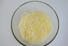 土豆洗凈後去掉皮切成絲，直接刨入有清水的碗中；