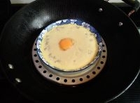 大火隔水蒸5分鐘，轉中火2分鐘，蒸至雞蛋液稍微有些凝固，在蒸盤當中放入蛋黃；