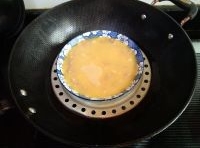 蛋液過篩倒在肉糜上，放入蒸鍋，用盤子扣住；
