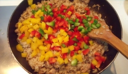 等到米飯熟后加入紅椒，黃椒，青椒丁，再放入鹽和雞精后，最後拌勻可出鍋。
