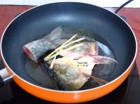 熱鍋，倒油，放入腌制好的魚頭、魚尾、加生薑絲小火煎，微黃翻轉一次；