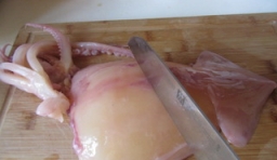 魷魚清洗乾淨后，用刀把魷魚表面上薄膜颳去，切成細條；
